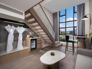 A modern hotel room with a staircase, a seating area, and a view of the city. - Holiday Inn Hefei City Center by IHG (Hefei)