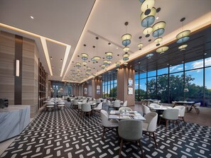 A spacious hotel lobby with a patterned floor, multiple dining tables, and a large window offering a view of the outdoors. - Holiday Inn Hefei City Center by IHG (Hefei)