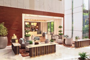 A modern lobby with a reception desk, seating area, and large windows. - Taj City Centre Gurugram (Gurugram)