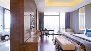 Una habitación de hotel moderna con una cama grande, un sofá, un escritorio y un televisor montado en la pared.