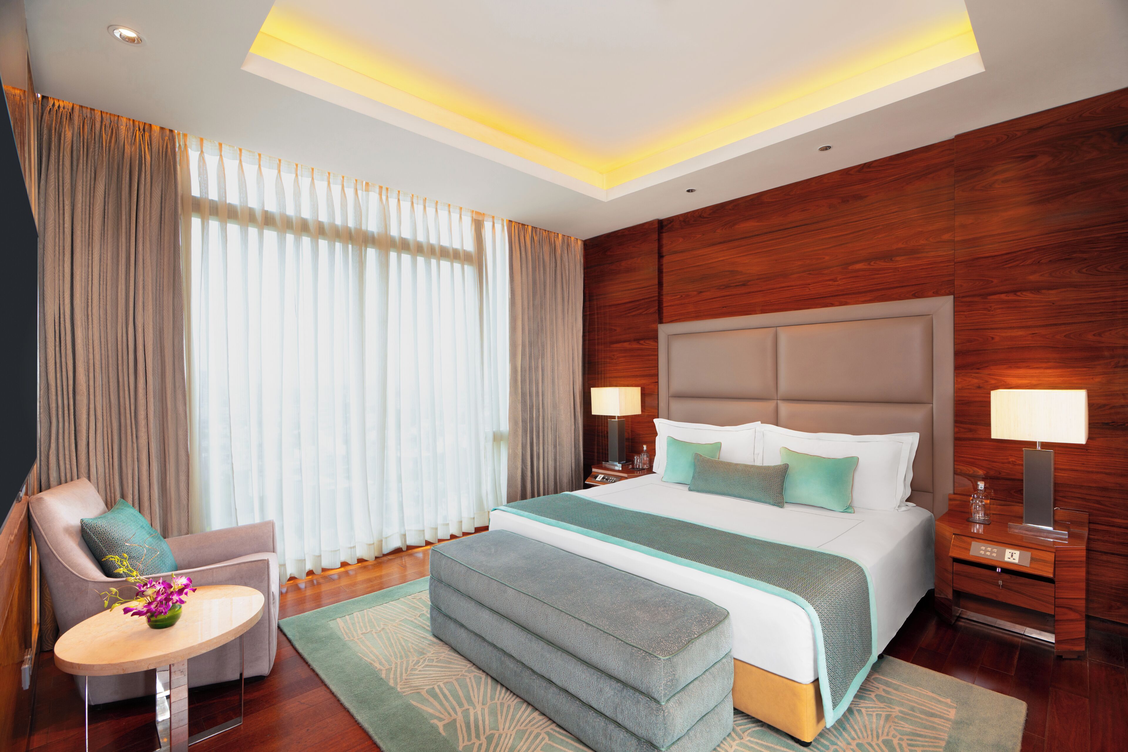 Une chambre d’hôtel avec un grand lit, des lampes de chevet, un bureau et une chaise.