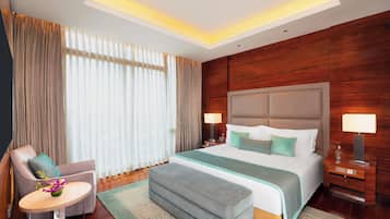 Une chambre d’hôtel avec un grand lit, des lampes de chevet, un bureau et une chaise.