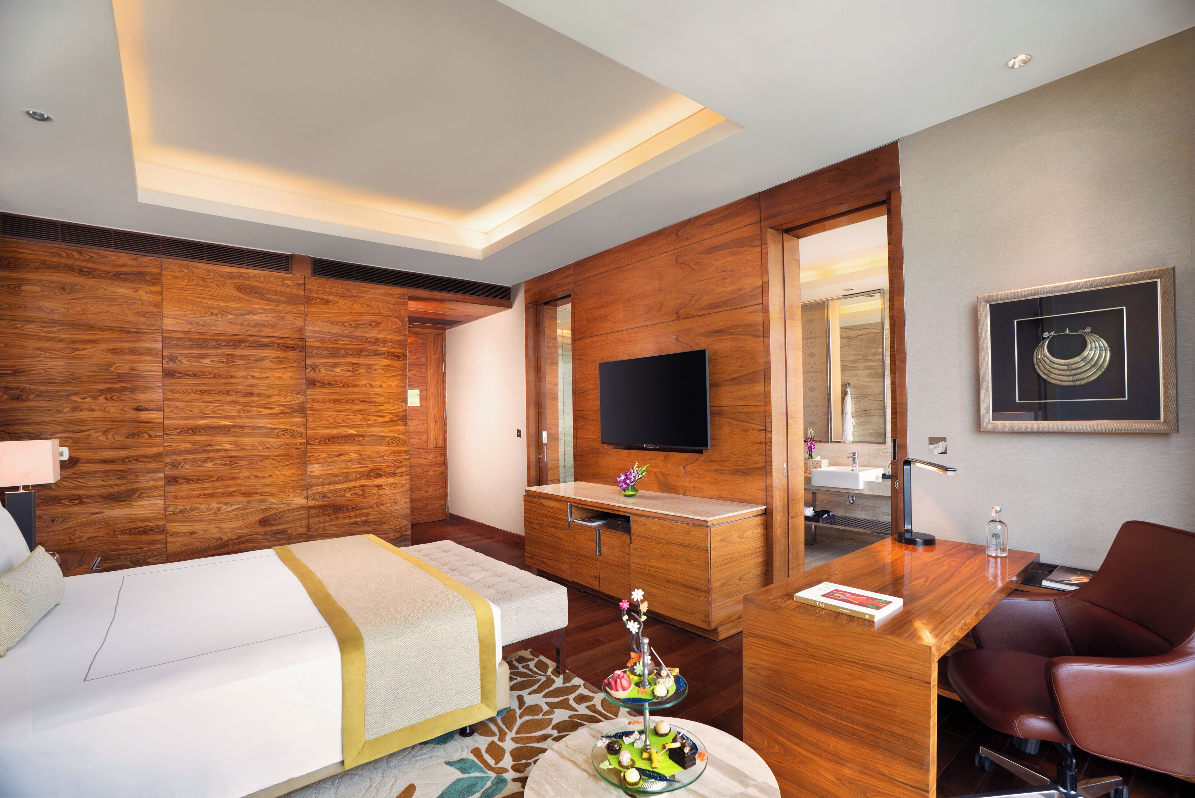 A hotel room with a bed, a desk, a chair, a television, and a bathroom.