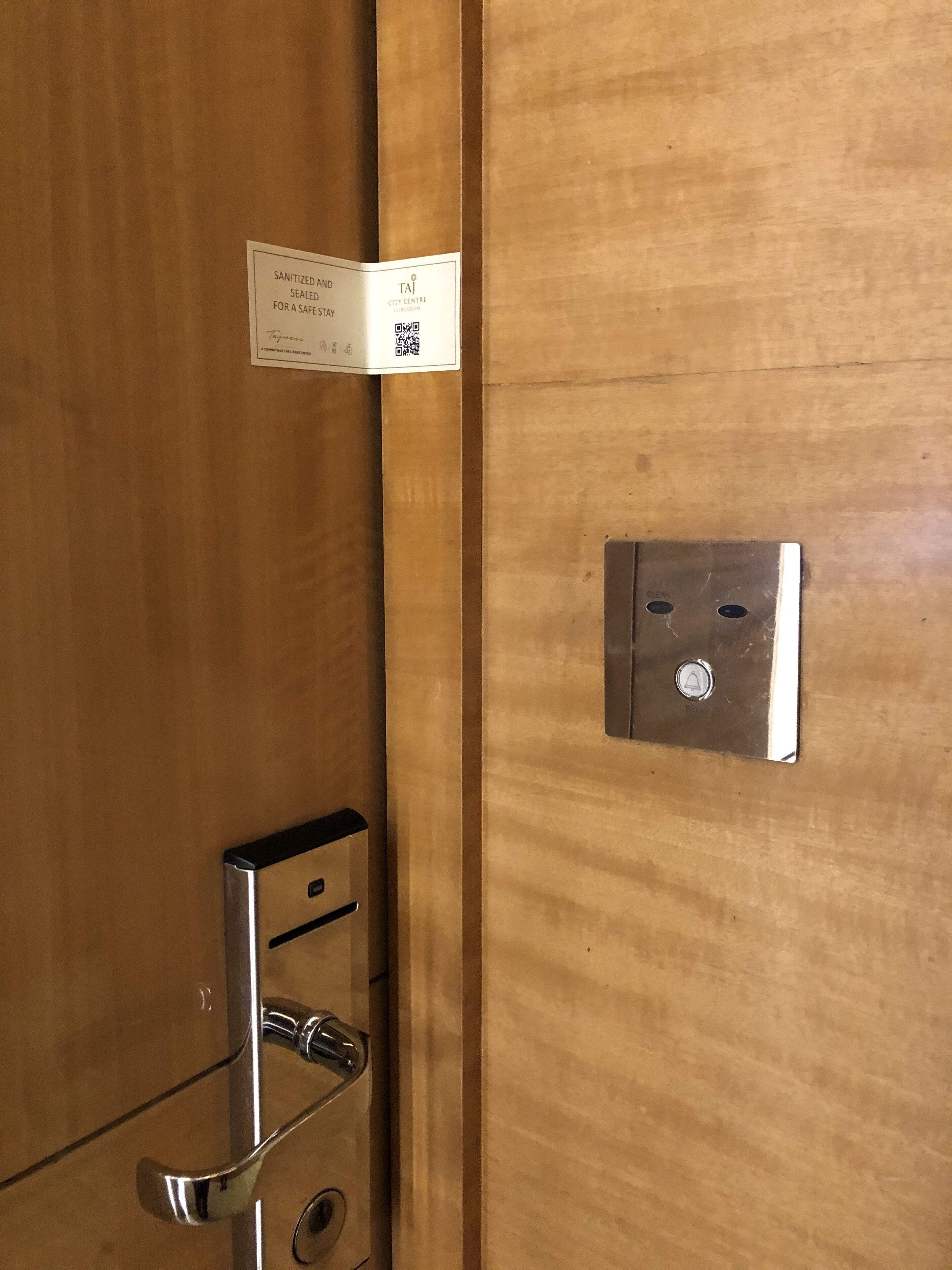 A wooden door with a metal handle and a keycard reader.