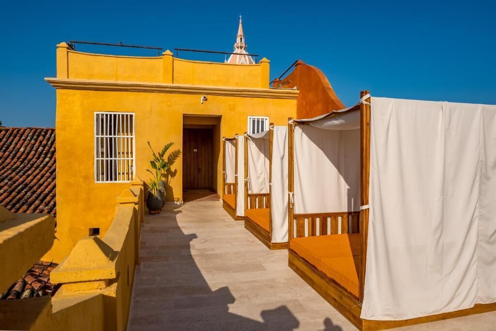 A yellow building with a tiled roof, a door, and a small window.