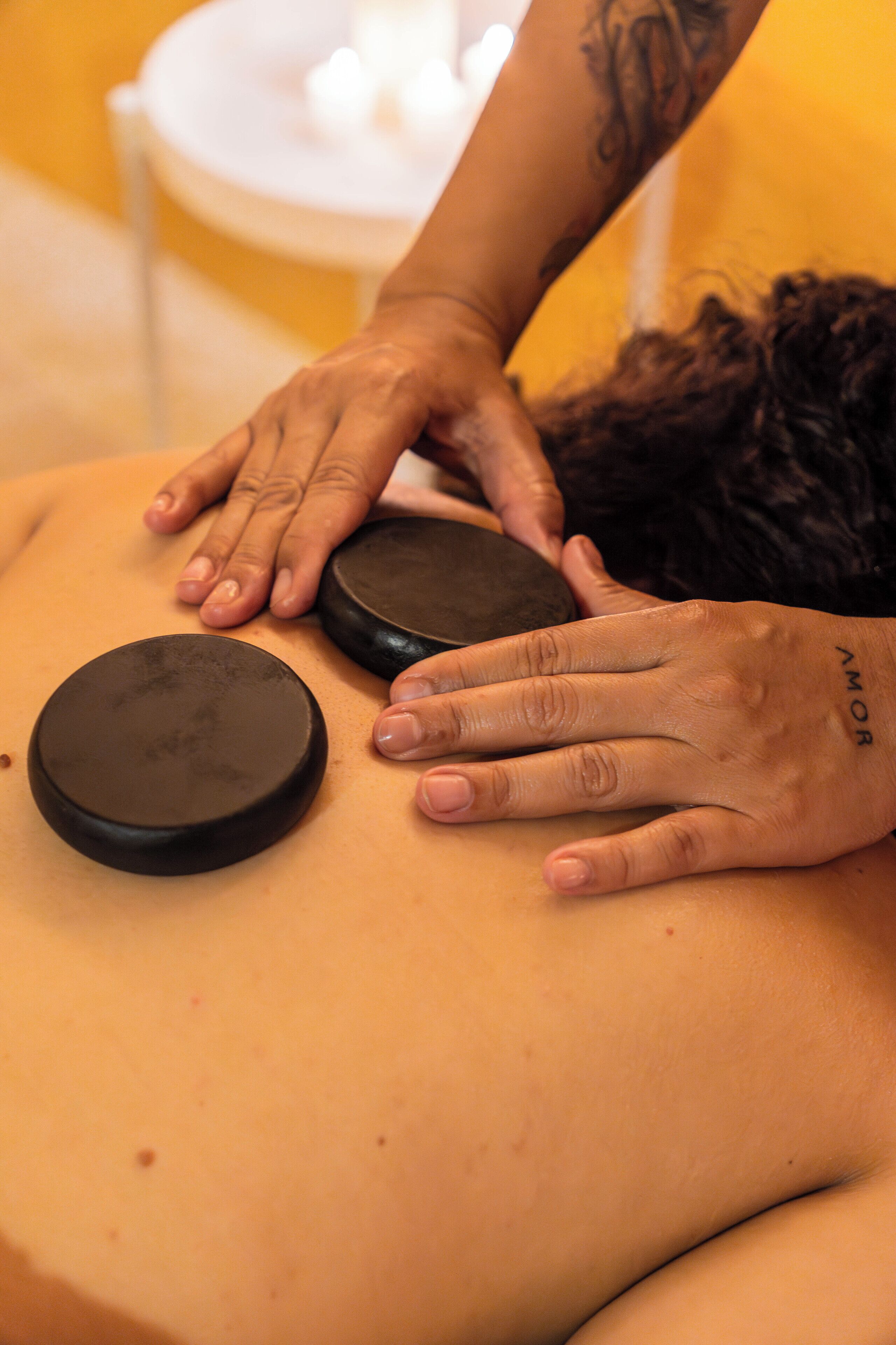 A massage therapy session with a person lying face down receiving a back massage.