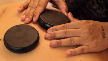 A massage therapy session with a person lying face down receiving a back massage.