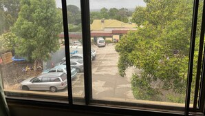 Un estacionamiento con varios coches y un edificio al fondo.