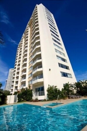 A high-rise hotel with a swimming pool in the foreground. - Pacific Plaza Apartments (Surfers Paradise)