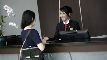Una recepción con una recepcionista y una mujer.