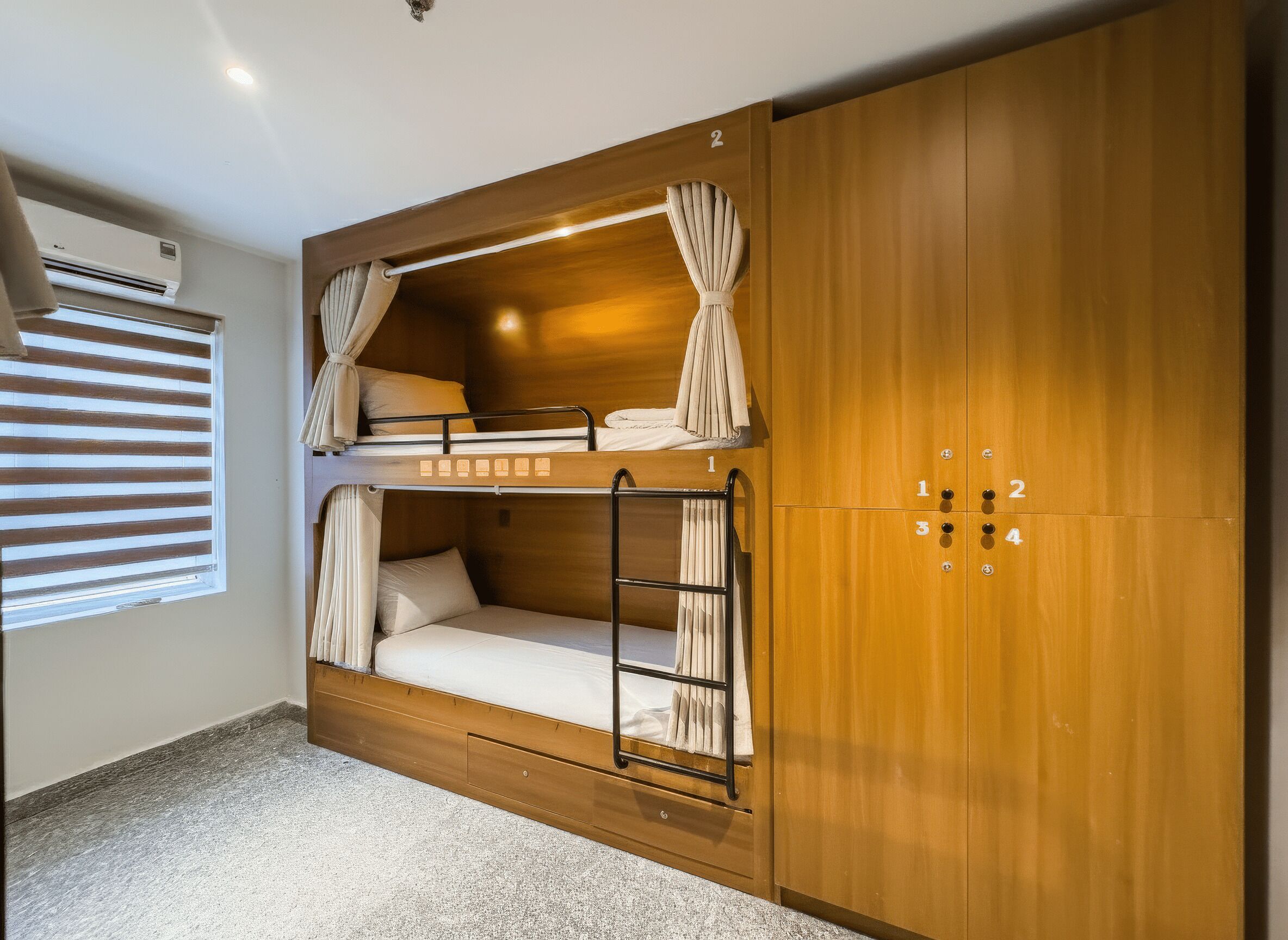 A bunk bed room with wooden walls, a window with blinds, and a number lock cabinet.