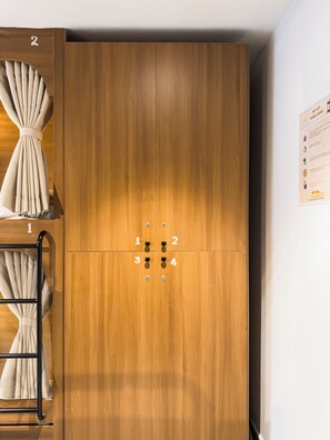 A wooden wardrobe with a number lock system and a ladder for storage. -  Gold Central Hotel Danang a Salve by Haviland  (Da Nang)
