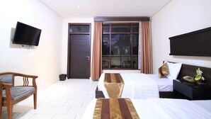 A hotel room with a bed, a chair, a television, and a window with curtains. - Bakung Beach Resort (Kuta)