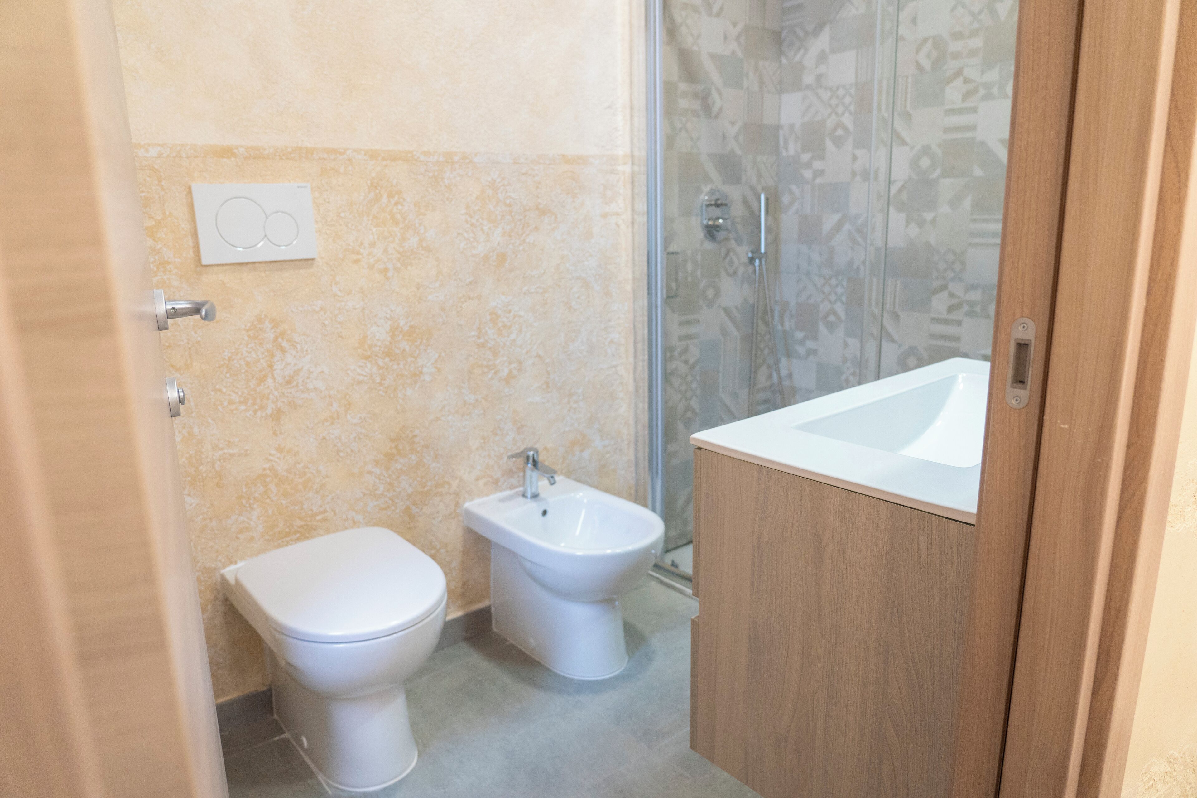 Un baño con inodoro, bidé y lavabo.