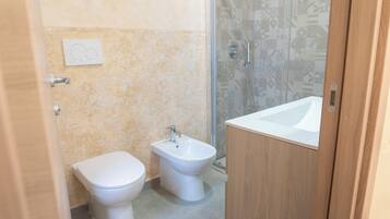Un baño con inodoro, bidé y lavabo.