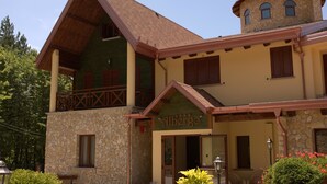 A two-story building with a stone facade, a balcony with wooden railings, and a sign that reads "Albergo". - Albergo della Posta (Taverna)