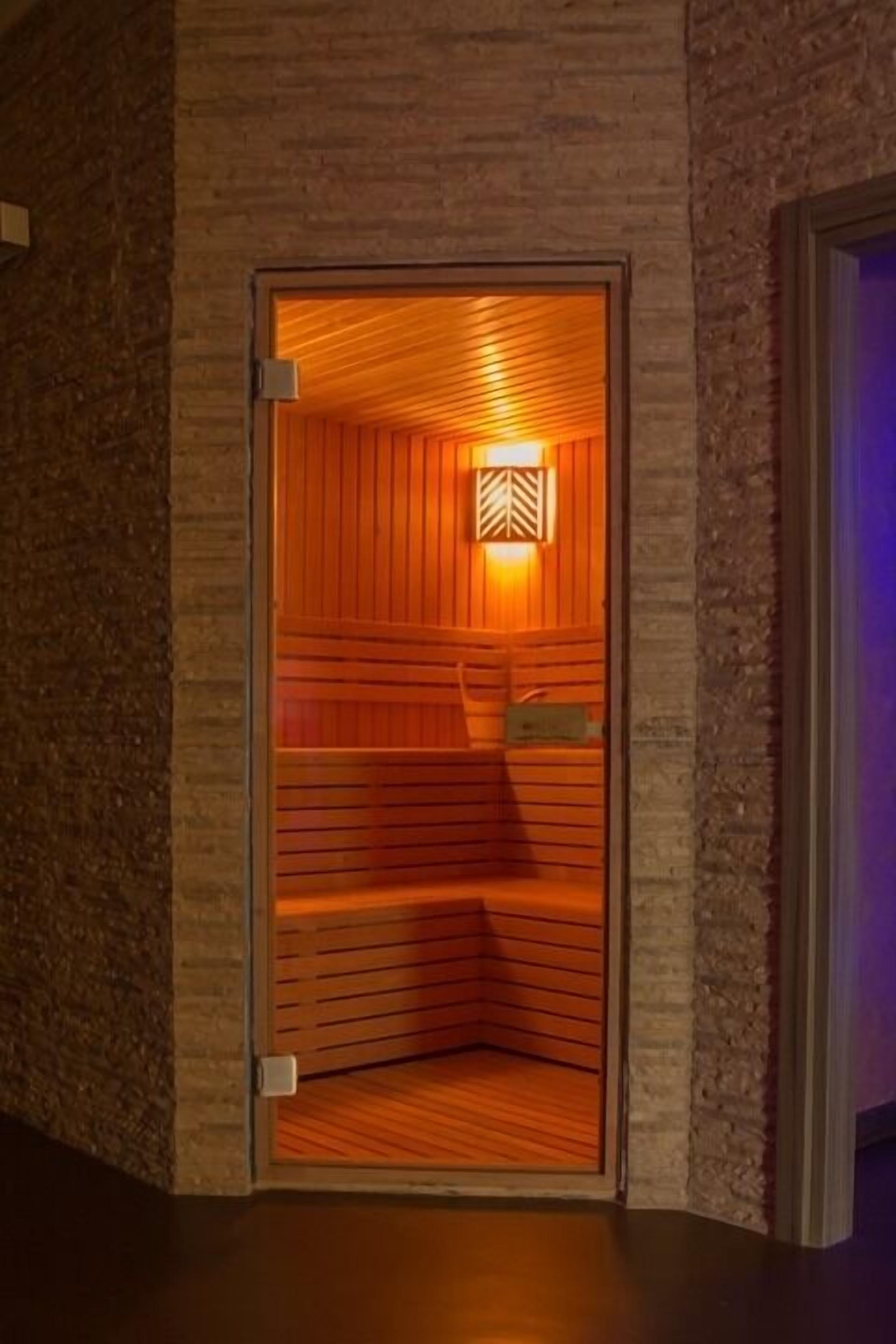 Una sauna con paredes de madera y un banco en su interior.