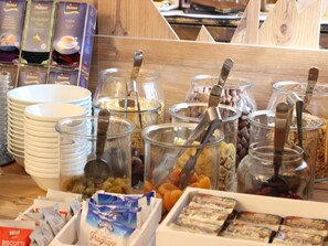 A breakfast buffet with various food items and containers. - Hotel Rosalpina (Soraga)