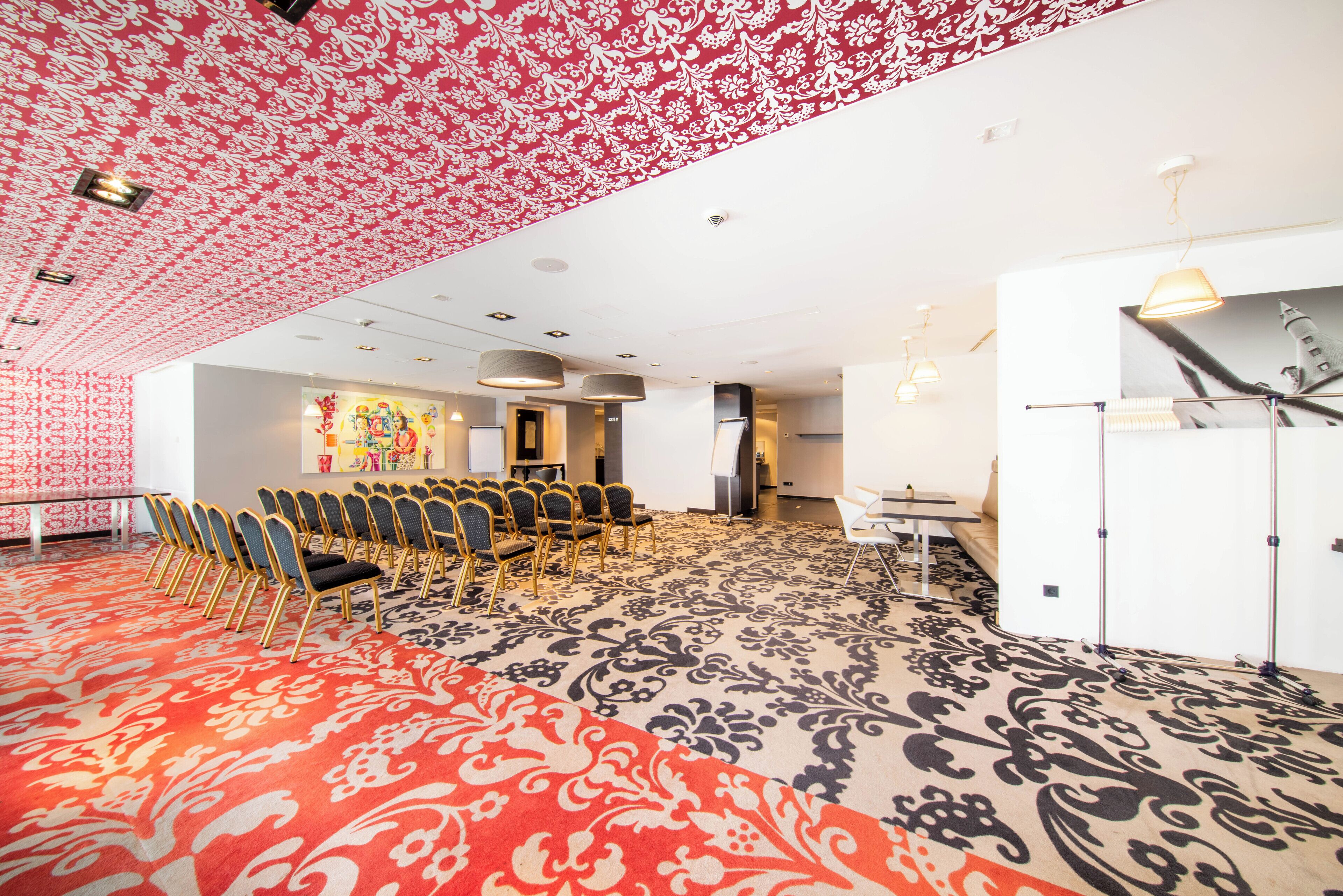 A conference room with a patterned carpet, rows of chairs, a whiteboard, and a large window.