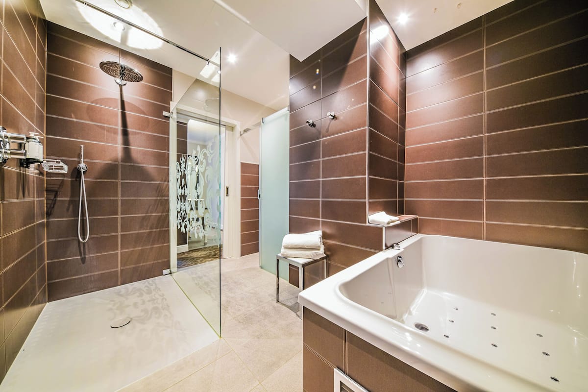 A modern bathroom with a glass-enclosed shower, a standalone bathtub, and a glass door leading to a shower area.