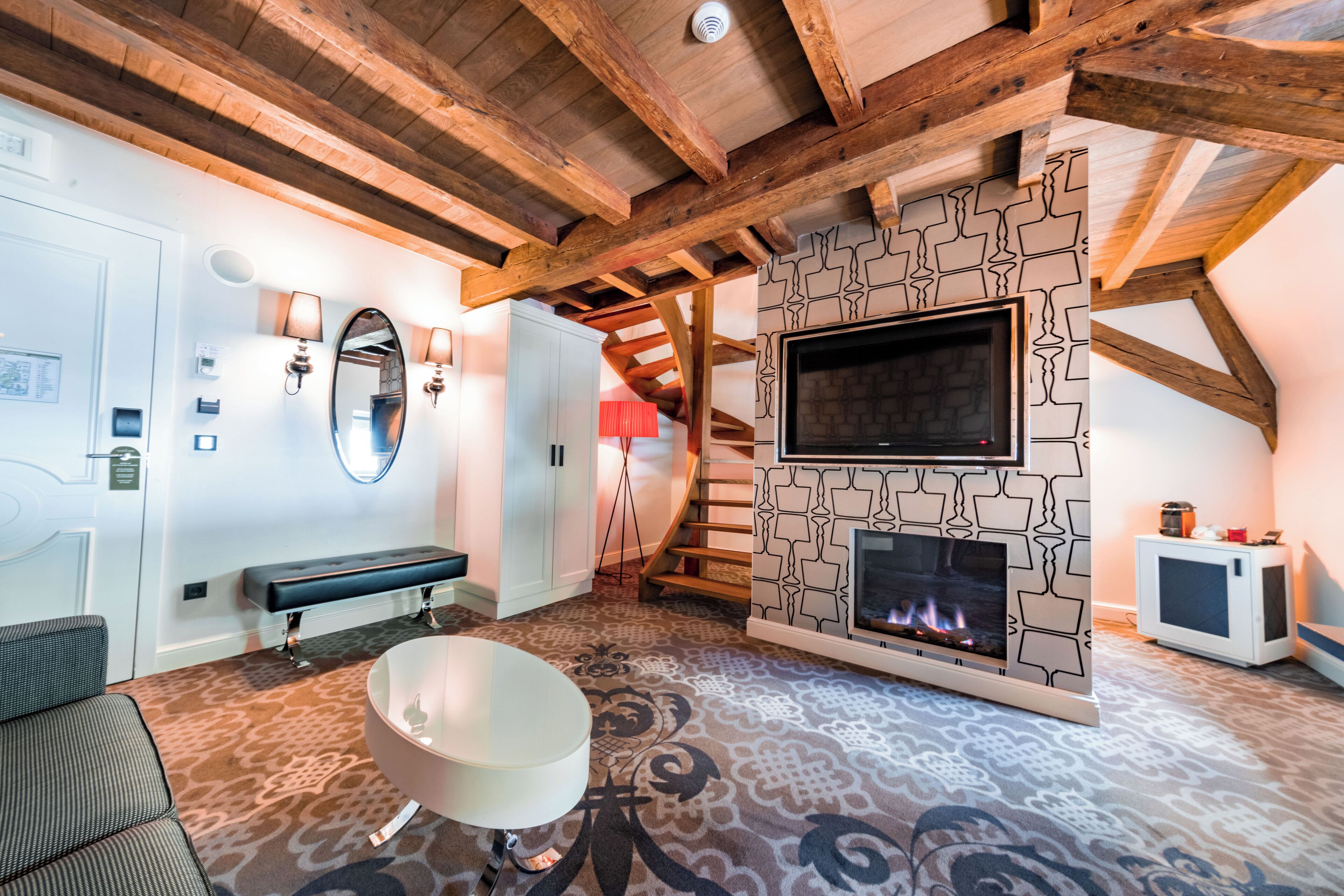 A modern living room with a fireplace, a television, and a bench.