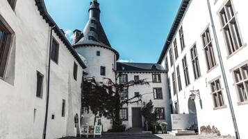 Un patio con una torre central, un edificio con una puerta y un cartel.