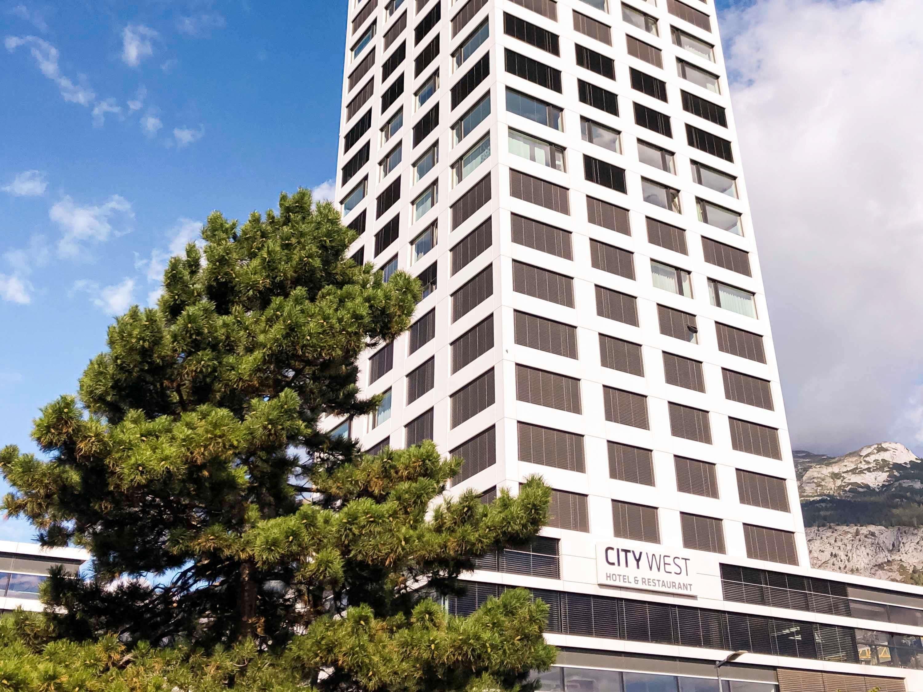 Un edificio de hotel alto con un letrero que dice 'CITY WEST HOTEL & RESTAURANT'.