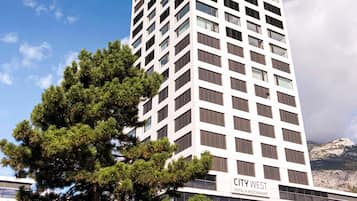 Un edificio de hotel alto con un letrero que dice 'CITY WEST HOTEL & RESTAURANT'.