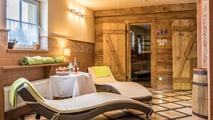 A spa room with two reclining chairs, a table with a bottle and glass, a lamp, and a window with a view. - Apartmán-Hotel Jítrava (Rynoltice)