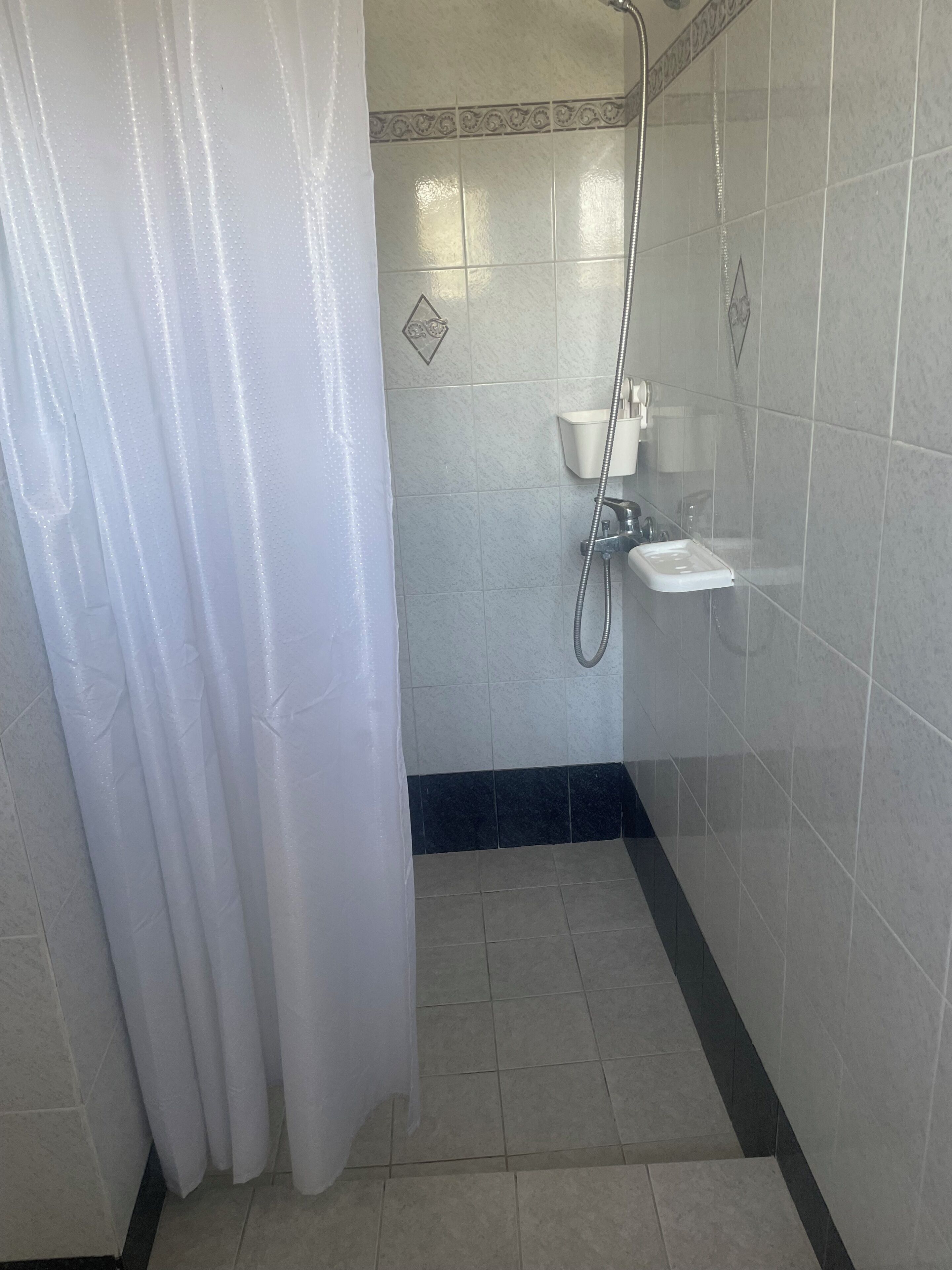 A bathroom with a shower, a sink, and a toilet.