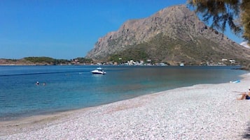 En la playa, playa de arena blanca y camas de playa (con cargo)