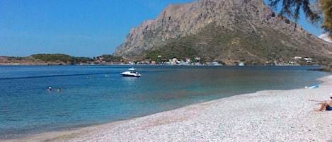 På stranden, hvit sand, strandtelt (mot et tillegg) og solsenger