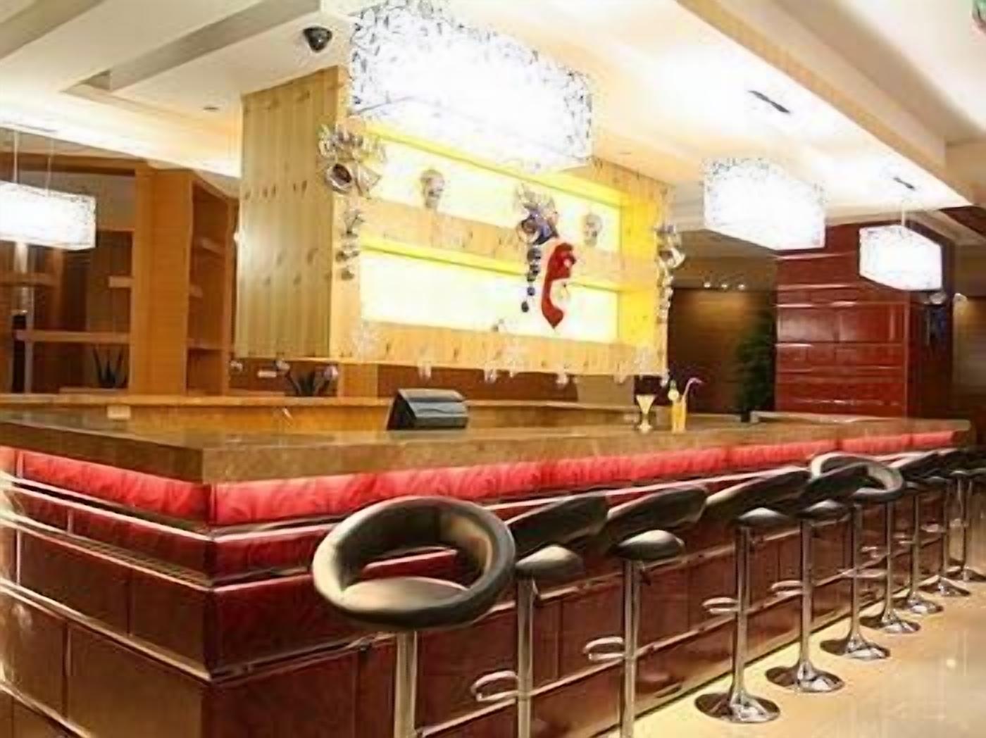 A bar area with a counter and multiple stools.