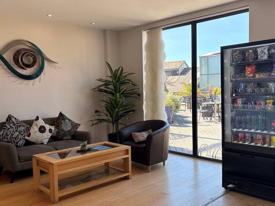 Una sala de estar moderna con un sofá, una mesa de centro y un ventanal grande.