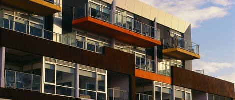 Un edificio a più piani con balconi, ampie finestre e un design architettonico moderno.