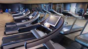 A gym with multiple treadmills, exercise balls, and weight machines.