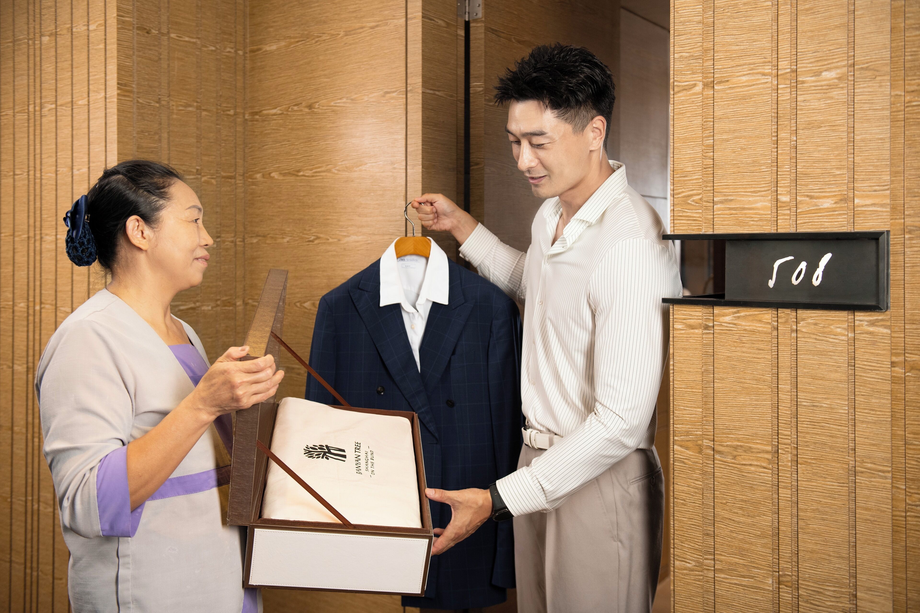 Ein Hotelzimmer mit Holzwandverkleidung und einem Schild mit der Zimmernummer 508.