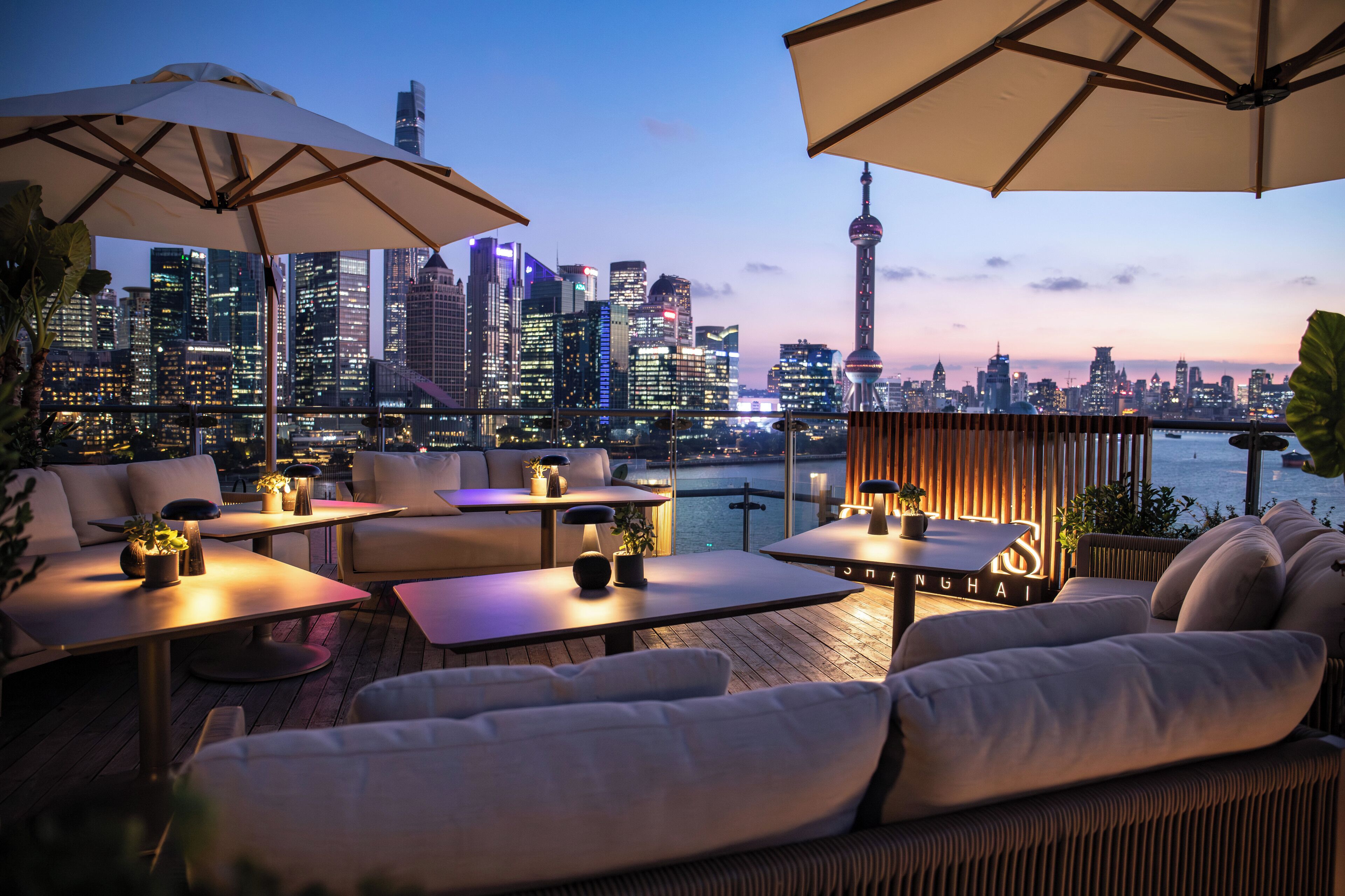 Une terrasse sur le toit, avec des sièges en plein air, des parasols et une vue panoramique sur la ville.