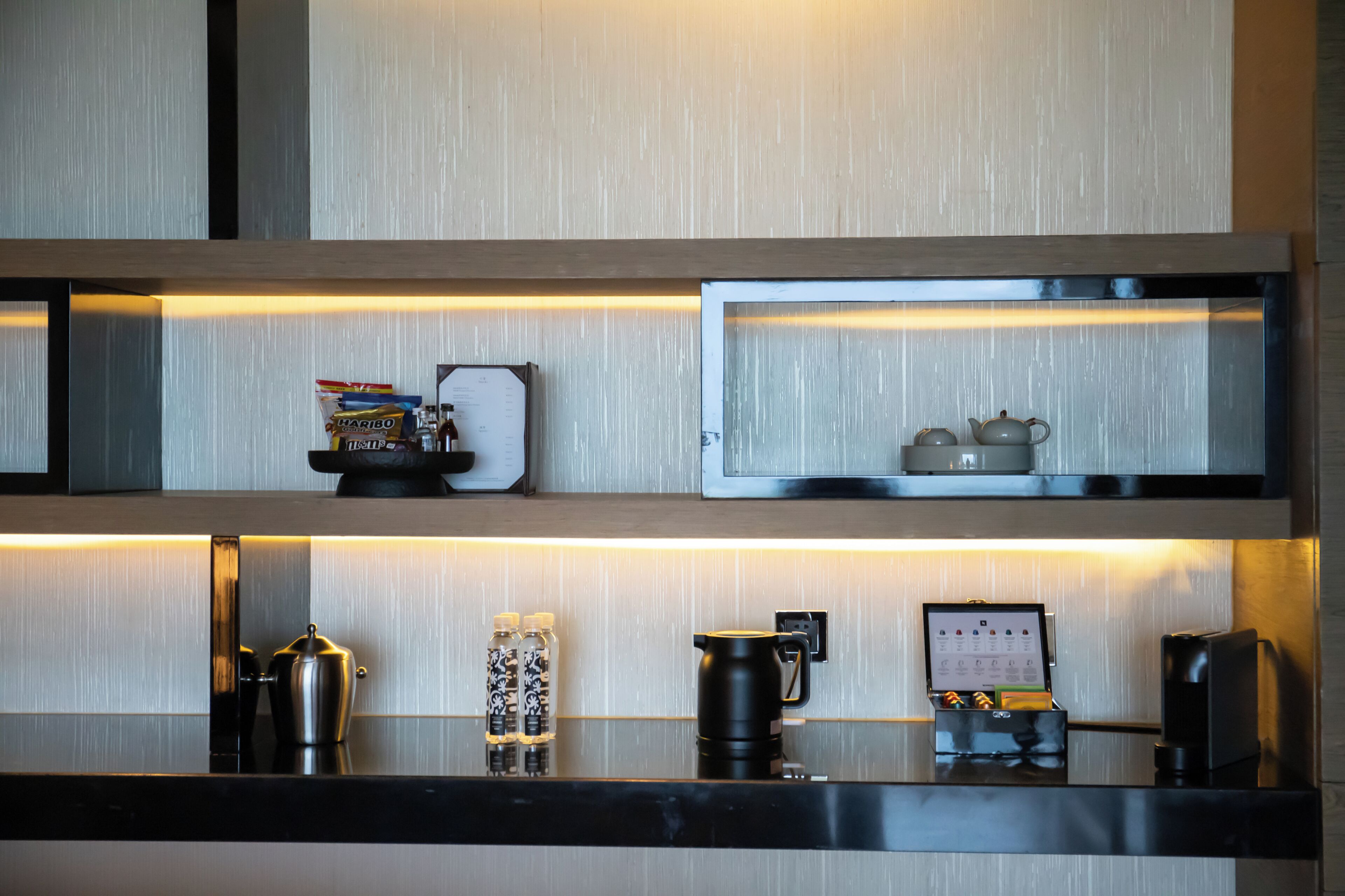 Et moderne køkken med kaffemaskine, elkedel og tesæt på disken.