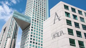 Een modern hoog gebouw met een opvallend 'AQUA'-bord op de gevel.