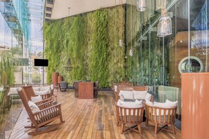 A wooden deck with seating and a vertical garden wall.