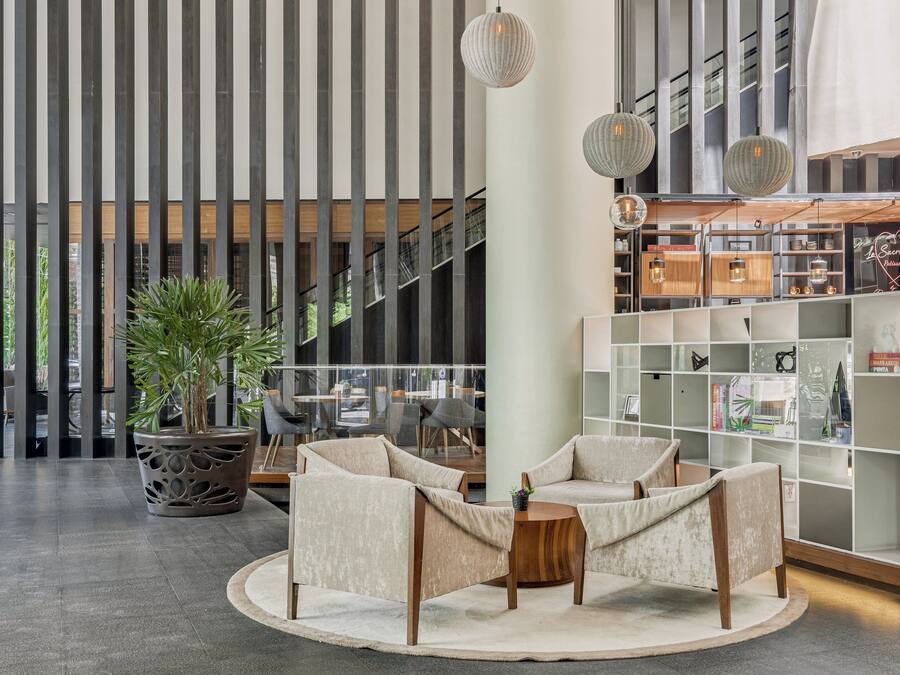 A modern interior with a seating area, a potted plant, and a bookshelf.