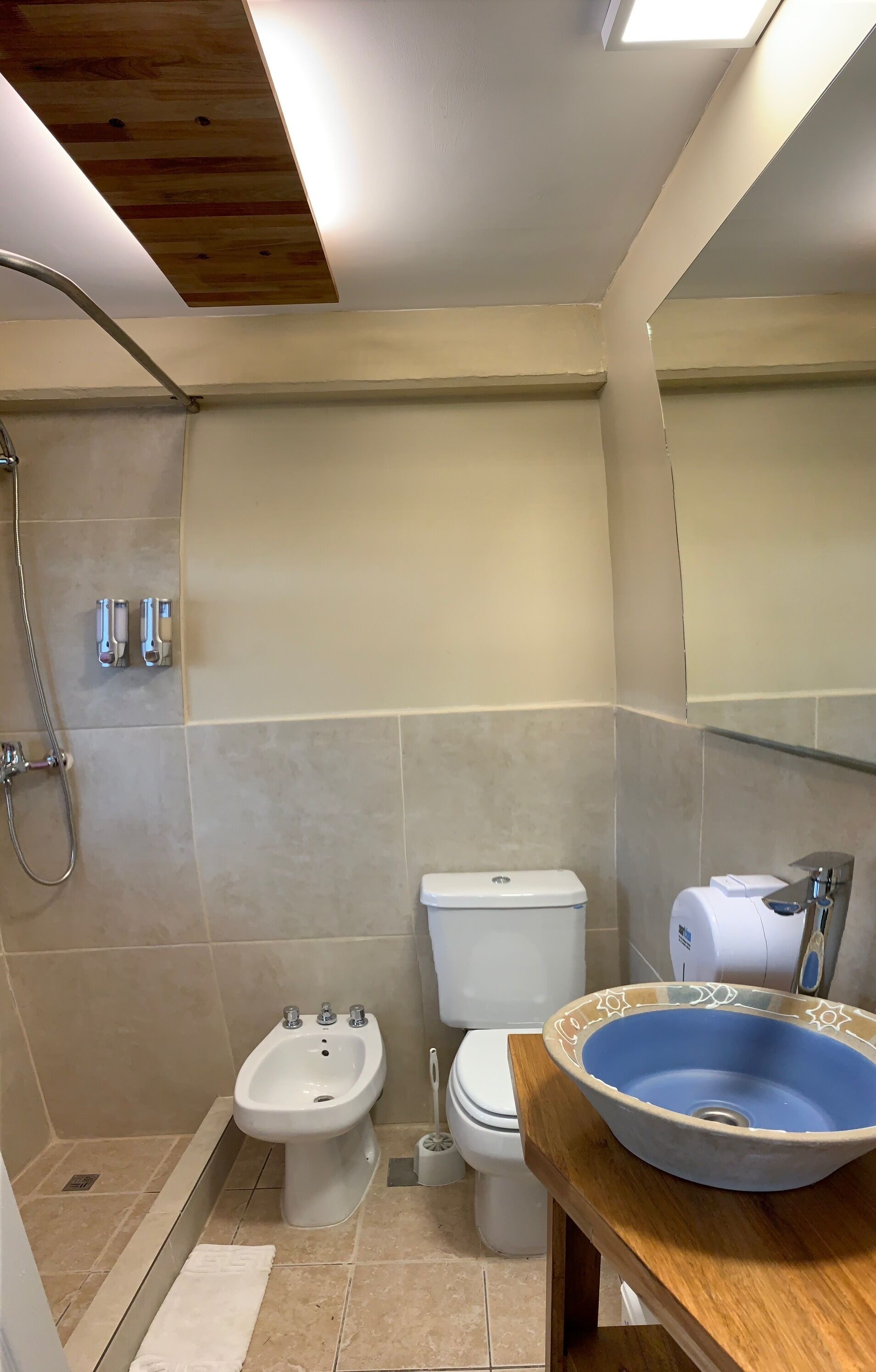 Baño con bidé, inodoro y lavamanos con lavabo azul.
