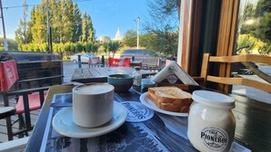A table with a cup of coffee, a plate of toast, a bowl of soup, and a jar of honey. - Hotel del Glaciar Libertador (El Calafate)