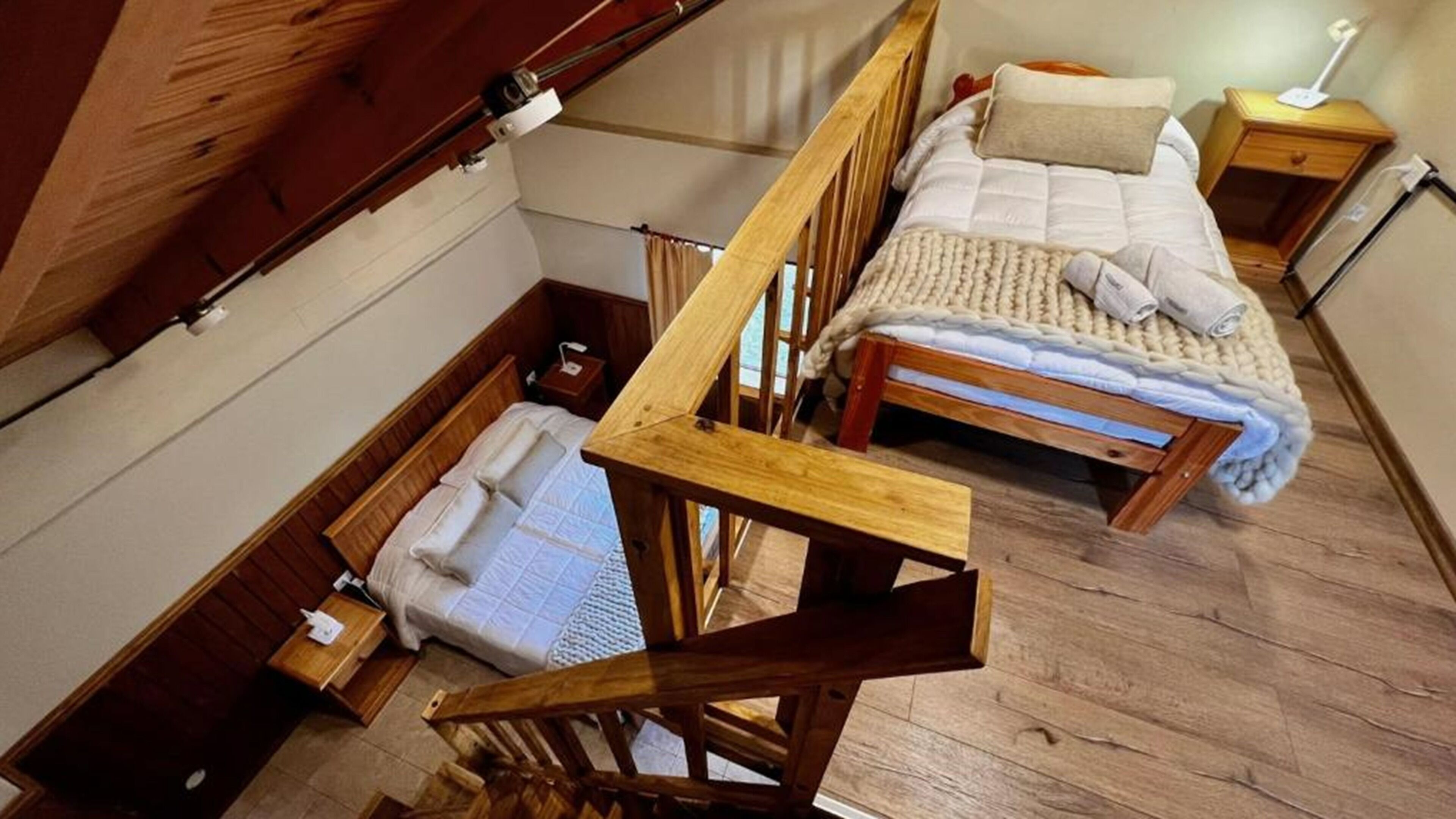 Un dormitorio estilo loft con dos literas de madera, una mesita de noche y una lámpara.