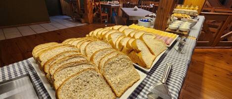 Una mesa de buffet con diferentes tipos de pan y otros alimentos.