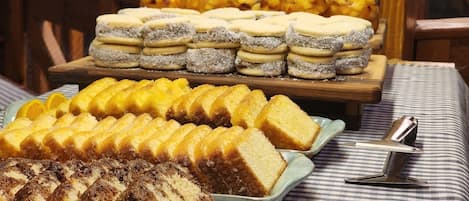 Une table de buffet avec divers desserts et un bocal de fruits.