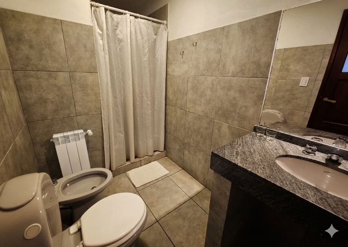 Een badkamer met toilet, bidet en wastafel met spiegel.
