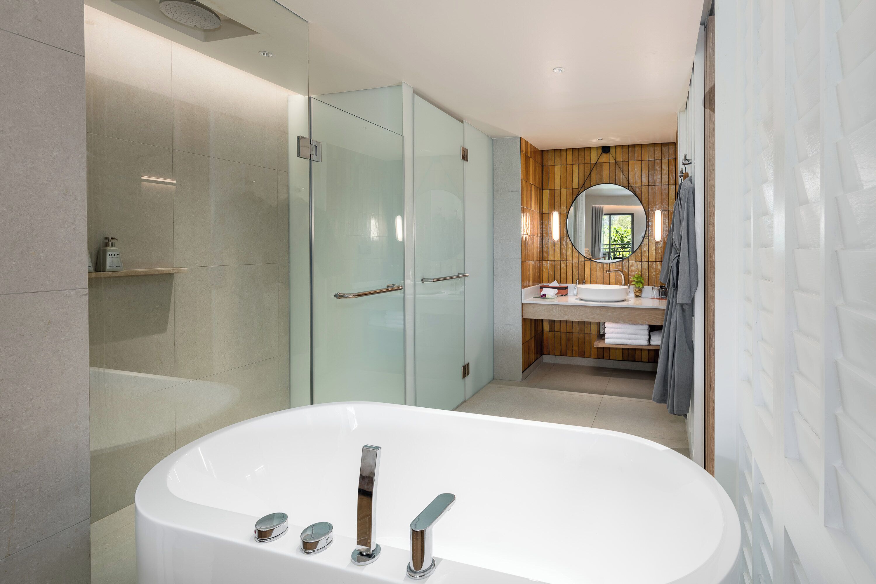 Une salle de bain moderne avec une baignoire sur pieds, une douche à parois de verre, un meuble-lavabo en bois et un grand miroir.