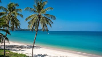 Na praia, espreguiçadeiras, guarda-sóis, toalhas de praia